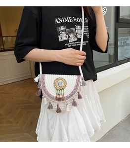 Detailed close-up of a bohemian woven shoulder bag with colorful beads and purple fringes