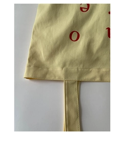 Detail of reinforced stitching and durable canvas texture on a yellow tote bag