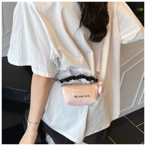 Détail du sac oreiller rose brillant avec poignée noire à volants et breloque cœur