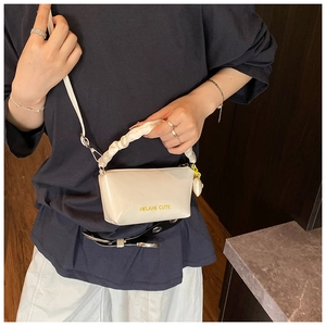 Détail du sac polochon crème avec poignée plissée et imprimé Helahe Cute porté par mannequin