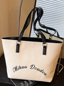 Sac fourre-tout minimaliste en toile beige avec anses noires et imprimé de lettres