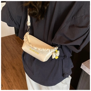 Détail du sac polochon blanc cassé avec texte HELAHE CUTE et breloque coeur sur la bandoulière