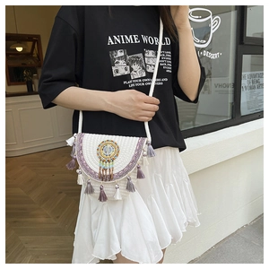Close-up of bohemian woven shoulder bag with purple tassels and beaded mandala ornament