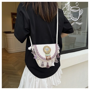 Detail of bohemian handmade woven bag with purple lace trim and colorful beaded tassels