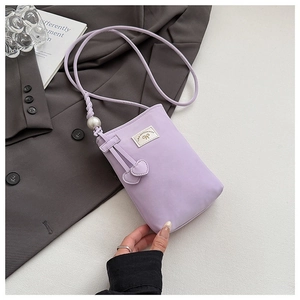 Detail of lavender mini phone bag with woven strap, large pearl and double heart charms