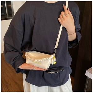 Détail d'un sac bandoulière blanc brillant avec bords à volants et texte Helahe mignon