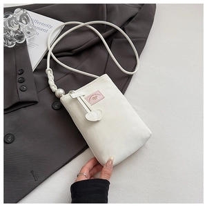 Detail view of a white PU phone bag with a large faux pearl and heart-shaped leather charms