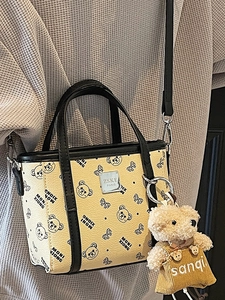 Sac à bandoulière beige minimaliste avec imprimé ours et poignées noires élégantes