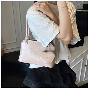 Detail view of the sleek pink shoulder bag with a stylish matching heart coin pouch