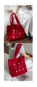 Detail of red canvas tote bag showing thick fabric texture and white letter prints
