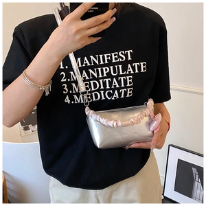Détail du mini sac argenté avec poignée rose à volants et décoration charme papillon
