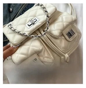 Close-up of white quilted mini backpack featuring multiple pockets and silver chain straps