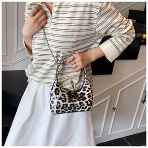 Detail of leopard print handbag with glossy finish and stylish metal chain strap