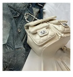 Detailed shot of cream quilted leather backpack with silver locks and chain handle