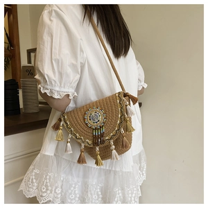 Detail of bohemian straw moon bag with colorful beads, fringe tassels and woven lace texture