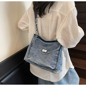 Detailed view of the washed denim shoulder bag with chain strap and silver twist lock