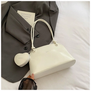 Detail of creamy white leather shoulder bag with matching heart-shaped coin purse accessory