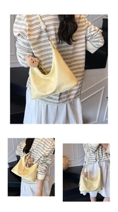 Close-up of pale yellow crescent bag with crocodile texture and plush bear charm