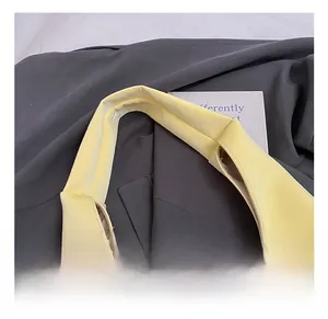 Macro detail of a soft yellow PU leather tote bag handle with wide integrated design