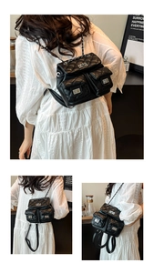 Detail of black quilted leather backpack with silver twist locks and chain straps