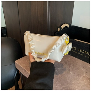 Détail du sac oreiller blanc crème avec logo ELAHE CUT jaune et charmant nœud
