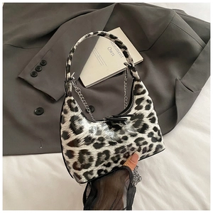 Detailed macro view of the glossy faux leather leopard print handbag with silver chain