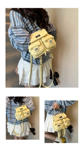 Detail view of quilted yellow mini backpack with silver chain handle and dual twist-lock pockets