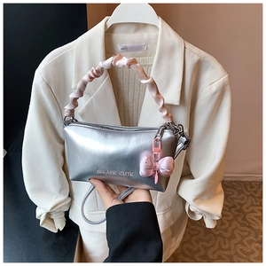 Sac oreiller métallisé argenté avec poignée à volants roses et nœud en velours