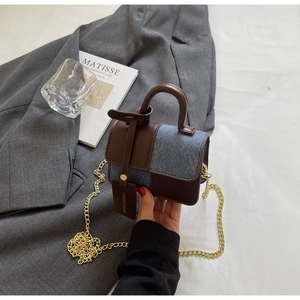 Detail view of contrast leather and denim mini square bag with golden chain strap