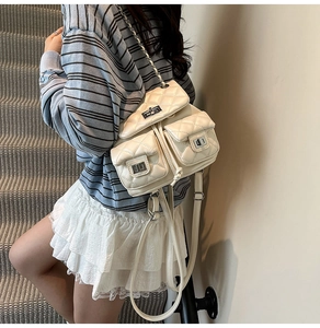 Detailed view of quilted chain backpack featuring three front pockets with silver twist locks