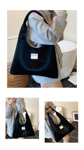 Detail showing high-capacity black tote bag texture and branded patch label for daily commute