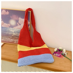Macro view of a colorful handmade crochet beach tote bag with striped mesh pattern
