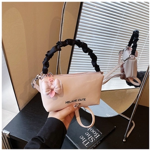 Détail du sac polochon rose de style doux avec poignée froncée et breloque noeud