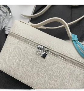 Dettaglio delle cerniere argentate e della pelle martellata sulla borsa beige di lusso