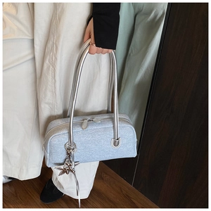 Détail du sac Boston bleu pailleté avec poignées argentées et breloque étoile