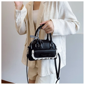 Chic black shell bag with lace trim and bow details worn with casual suit