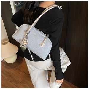 Détail du sac Boston argenté scintillant avec breloque étoile et bandoulière