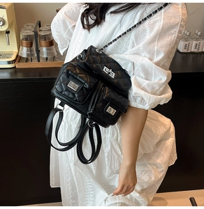 Detail of black quilted mini backpack with silver metal twist locks and chain straps