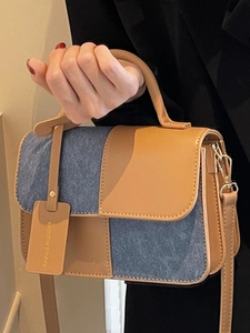 Brown leather and blue denim patchwork handbag with top handle and shoulder strap