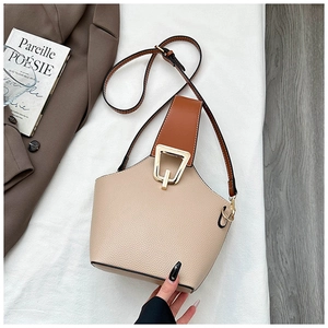 Dettaglio borsa a secchiello in pelle beige con chiusura geometrica dorata raffinata