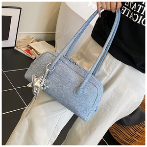 Détail du sac à main bleu clair en tissu avec pendentif étoile argentée et fines brides