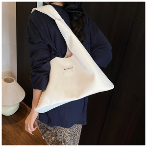 Detailed side view of the white large minimalist tote bag showing its unique triangular shape