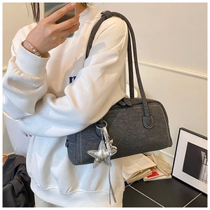 Détail d'un sac cabas gris foncé avec surpiqûres et breloque étoile argentée