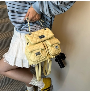 Detail of yellow quilted backpack featuring metal turn-lock closure and dual front pockets