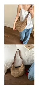 Detail of hand-woven straw hobo bag showing texture and adjustable brown leather strap