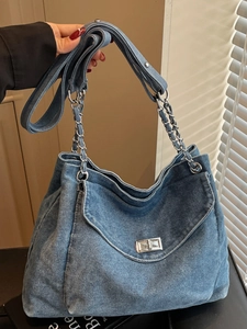Blue denim crossbody bag with silver chain strap and metal turn-lock for casual commuting