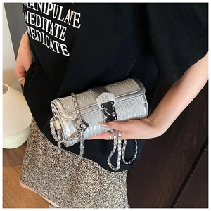 Close-up of silver cylinder chain bag with glitter texture and metallic M buckle detail