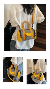 Close-up of minimalist grey and yellow contrast Boston barrel bag on wooden stairs