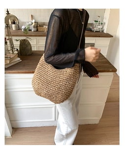 Detailed close-up of a large capacity woven straw hobo bag with natural fiber texture