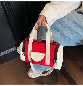 Detail of a mini cylinder Boston bag featuring a red and off-white contrast canvas design